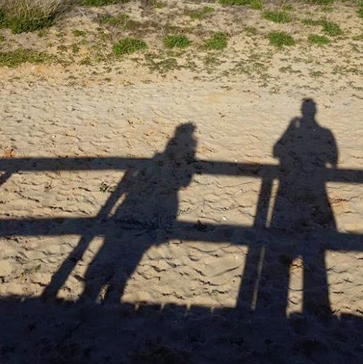 Schaduw van twee mensen op het zand