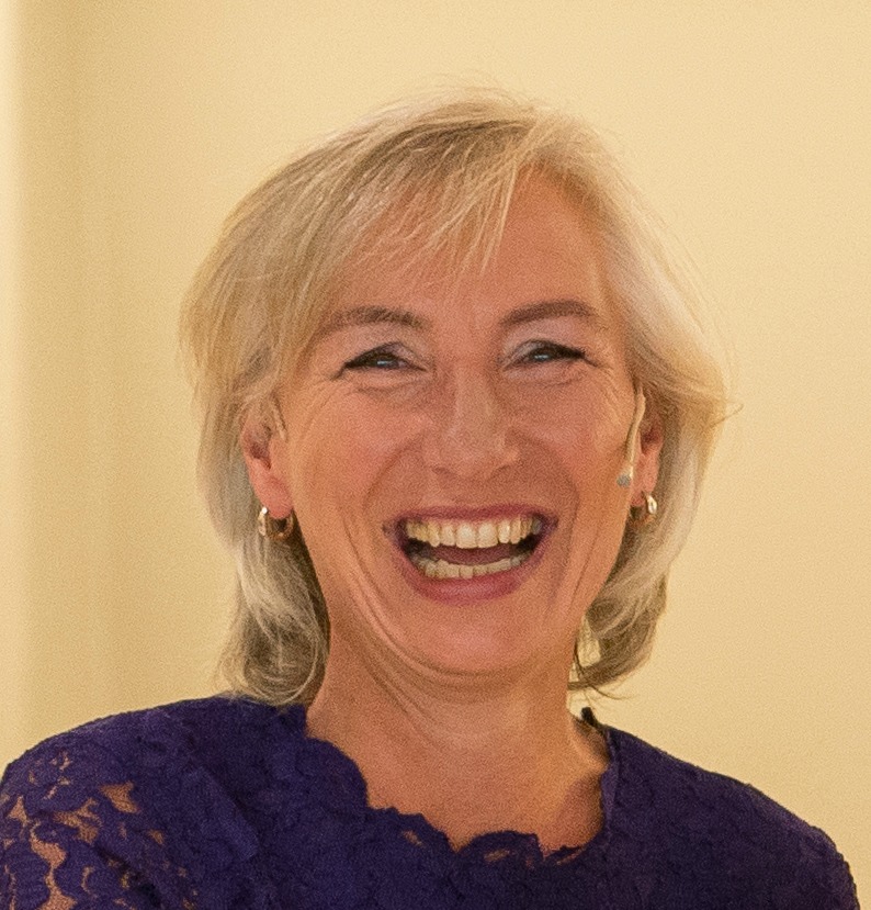 Linda Spaanbroek lachende vrouw met grijs blond haar in paarse jurk