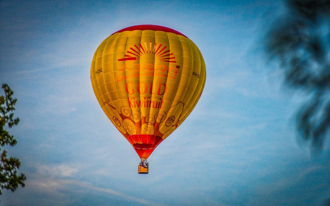 Geel met rode luchtballon voor een blauwe lucht