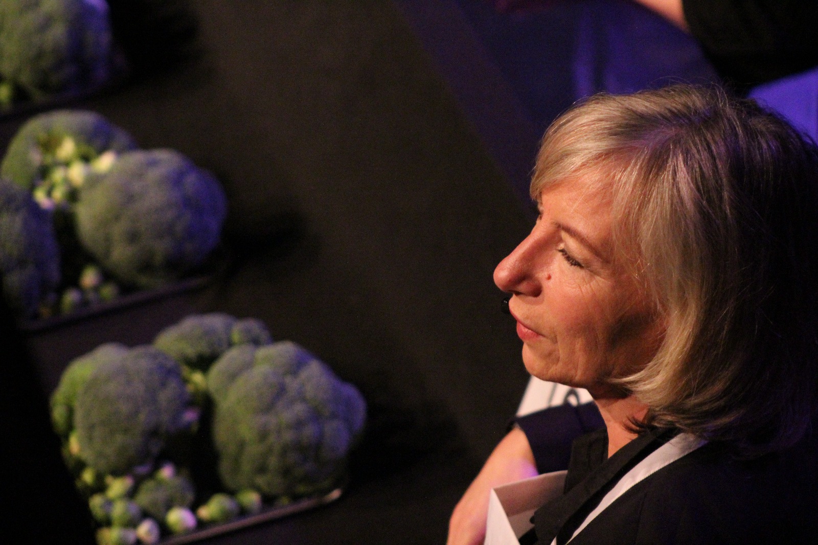 Linda Spaanbroek naast toonbank met broccoli en spruitjes
