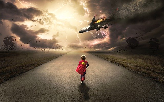 jongetje in superman outfit loopt midden op een asfalt weg richting een neerstortend vliegtuig en bliksem