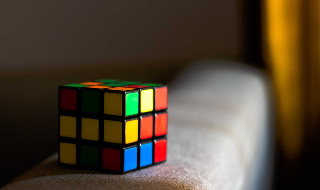 rubix-kraak-de-code Bril op bureau met beelscherm met codes erop en tekst kraak de code intensieve begeleiding